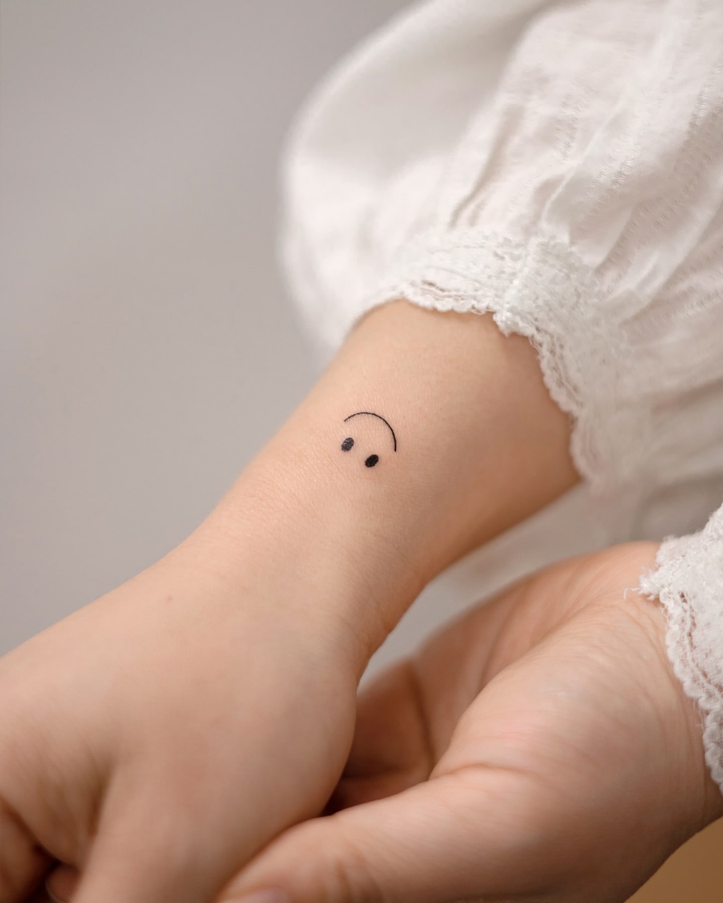 Upside-Down Smiley Face Wrist Tattoo Playful and Ironic Minimalist Design