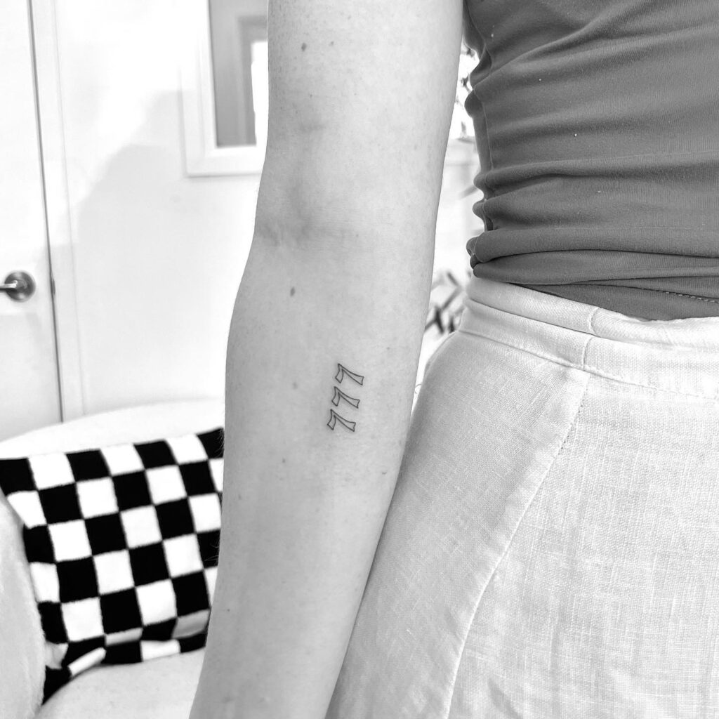 Vertical 777 Old English Tattoo with a Chic Twist: Forearm Flourish 