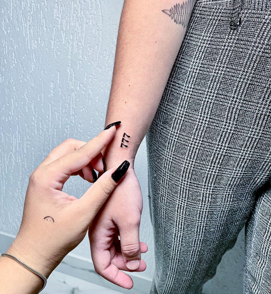 Vertically Placed 777 Tattoo in Black Work Style: Wrist Statement 