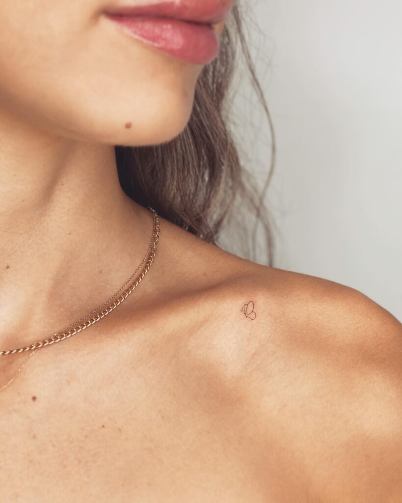 Very tiny butterfly outline on the collarbone: side view flight