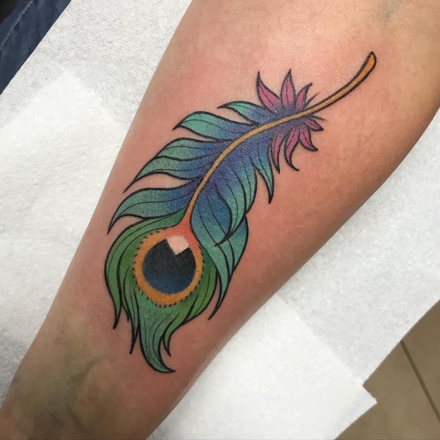 Vibrant and colorful peacock feather tattoo on hand Vibrant and colorful peacock feather tattoo on hand