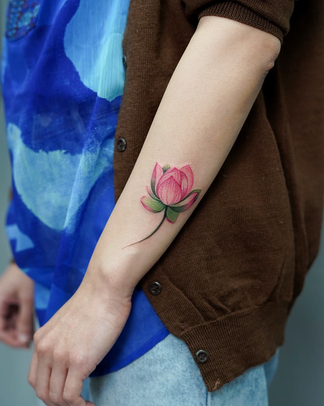Vibrant Lotus Flower Forearm Tattoo Symbolizing Purity and Strength