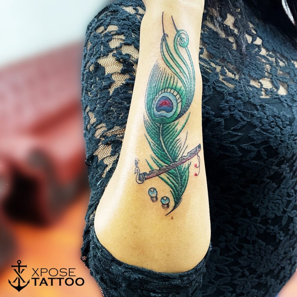 Vibrant outer forearm peacock feather tattoo for women a splash of colors
