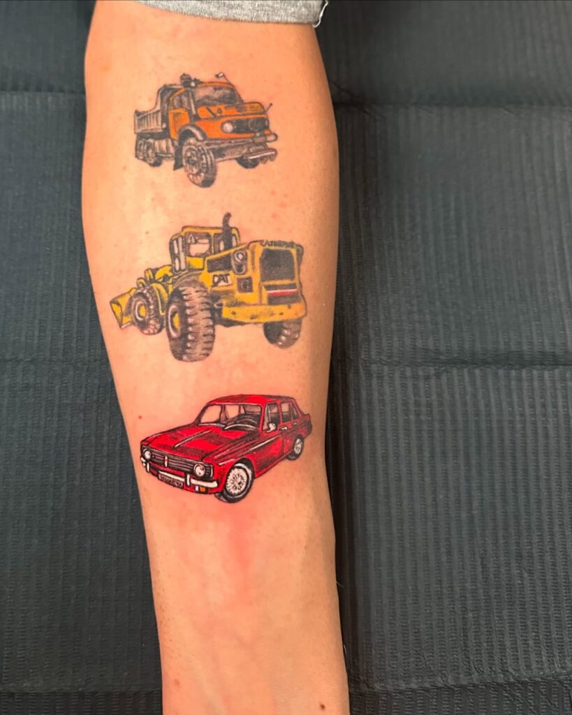 Vibrant Three-Vehicle Tattoo (Red Classic Car, Yellow Caterpillar Loader, Orange Dump Truck) on Inner Forearm – Car Tattoo Ideas