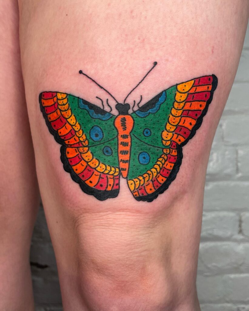 Vibrant wings full-color butterfly tattoo on the thigh