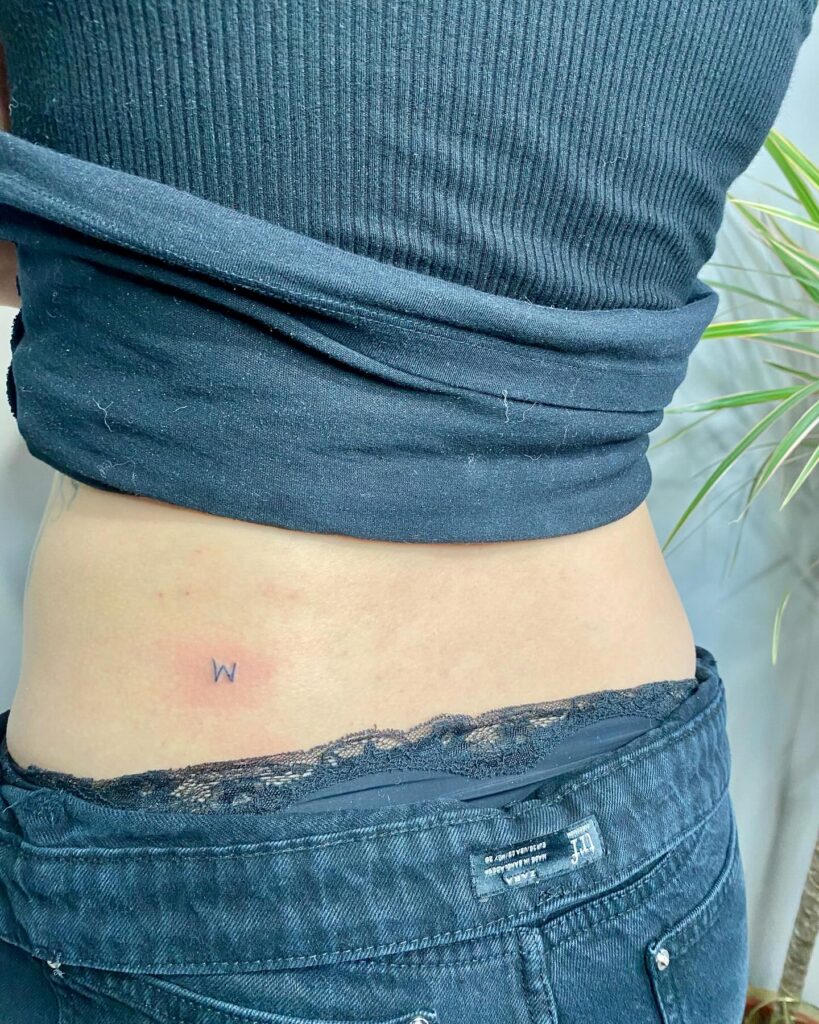 'W' Letter Tattoo on the Side for Women: Lower Back Elegance