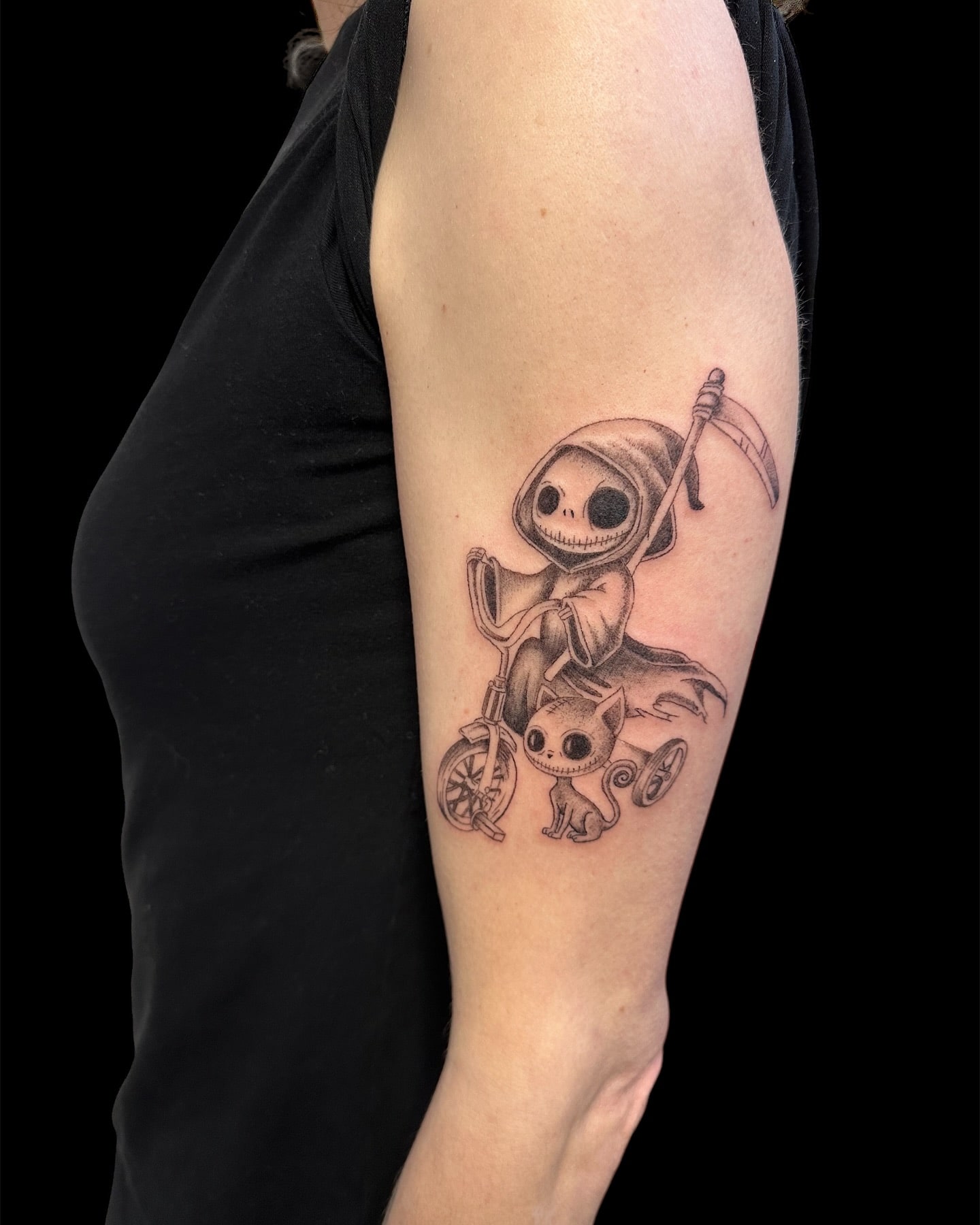 Whimsical yet slightly gothic Grim Reaper riding a tricycle tattoo with a spooky cat companion, perfect for fans of dark yet playful ink designs