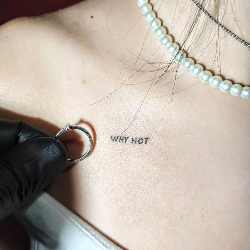 'Why not' word lettering tattoo making a statement on the collarbone in striking font bold wisdom