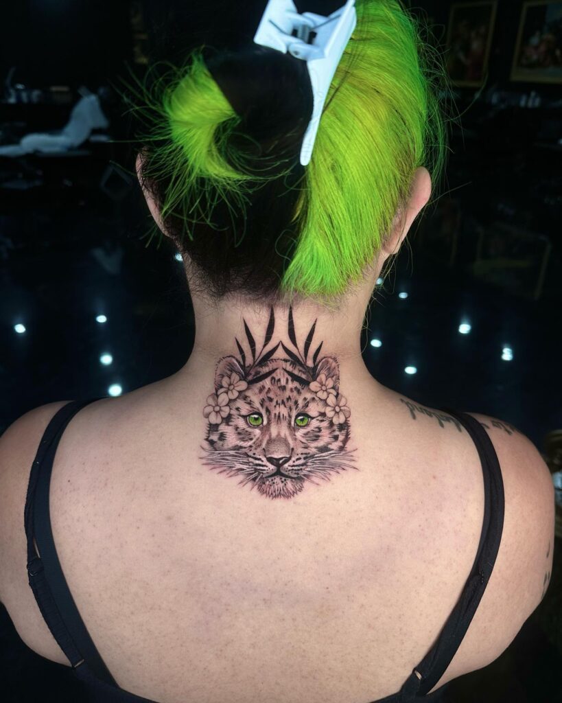 Wild elegance snow leopard tattoo with hypnotic green eye on the nape