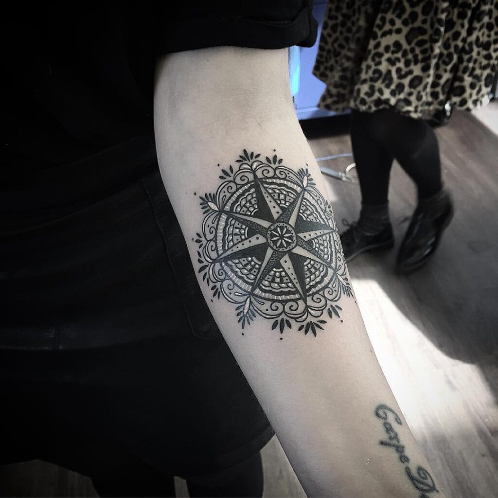 Wind rose on the background of mandala pattern a spiritual compass tattoo design