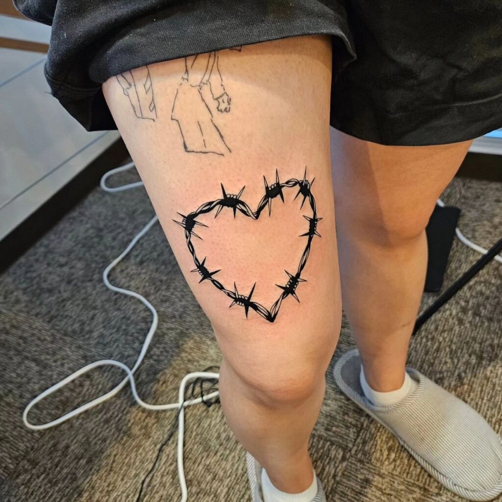 Wire heart tattoo above the knee artistry on your thigh