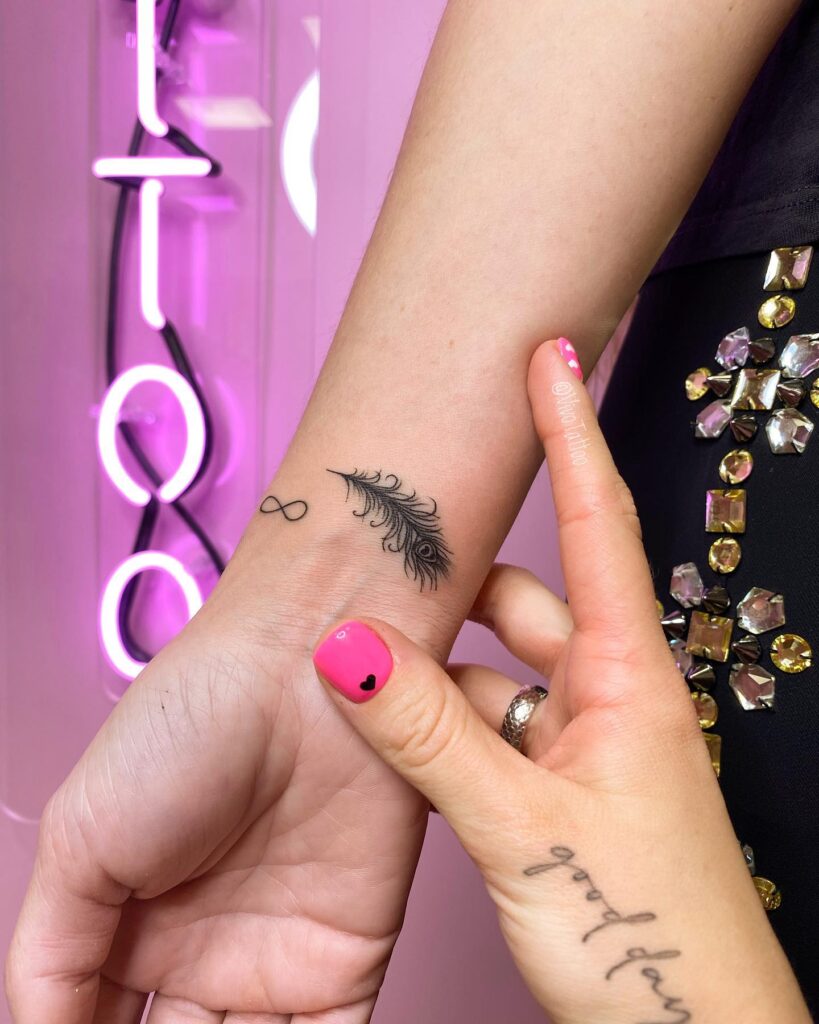 Wrist elegance small and subtle peacock feather tattoo on the wrist