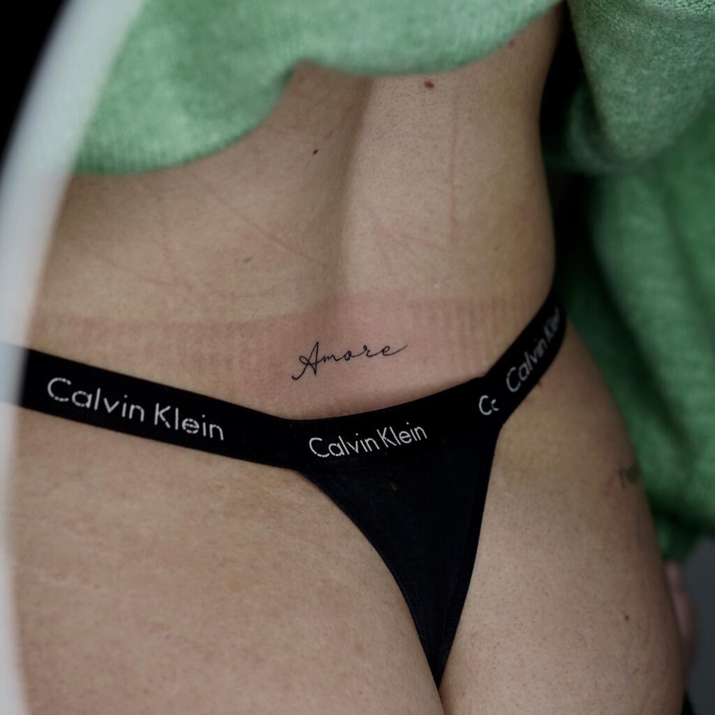 'Amore' Handwritten Text Lettering Tattoo on the Lower Back: Whispers of Love