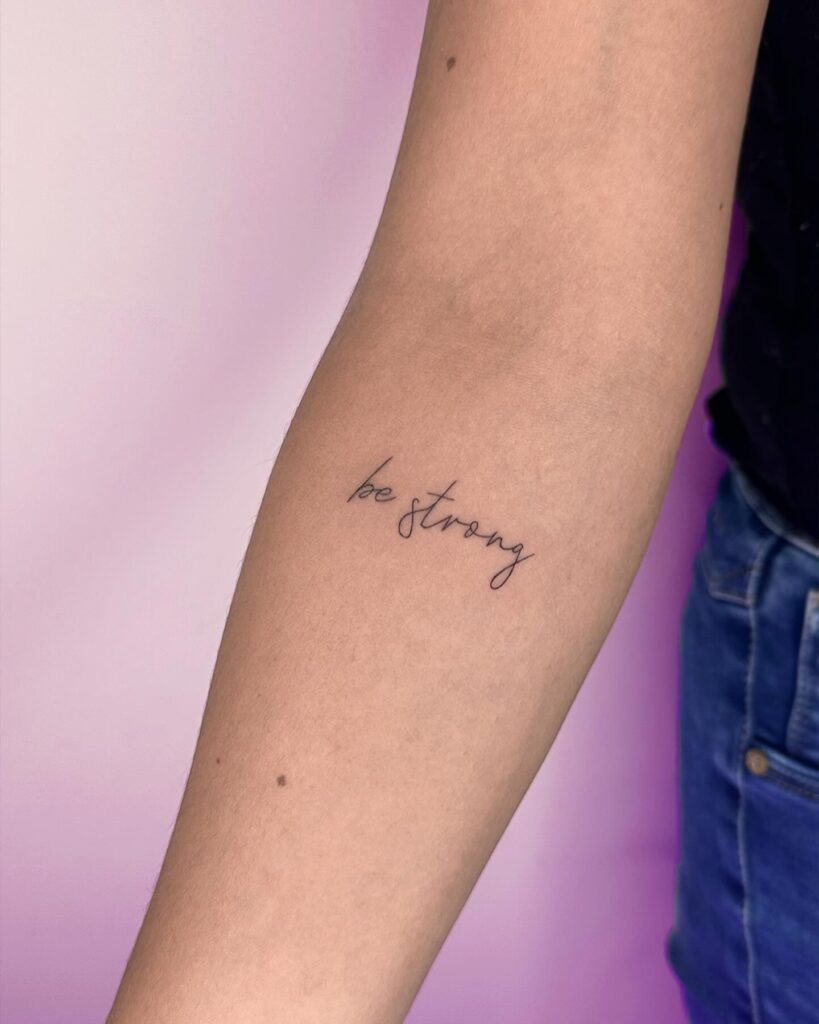 'Be Strong' Cursive Lettering Below the Elbow: Stylish Resilience