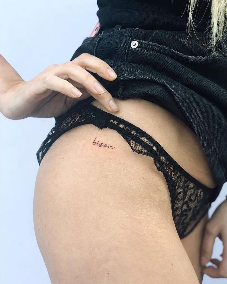 'Bisou' Text Lettering Tattoo on the Side Hip: French Elegance, a Chic Expression of a Kiss