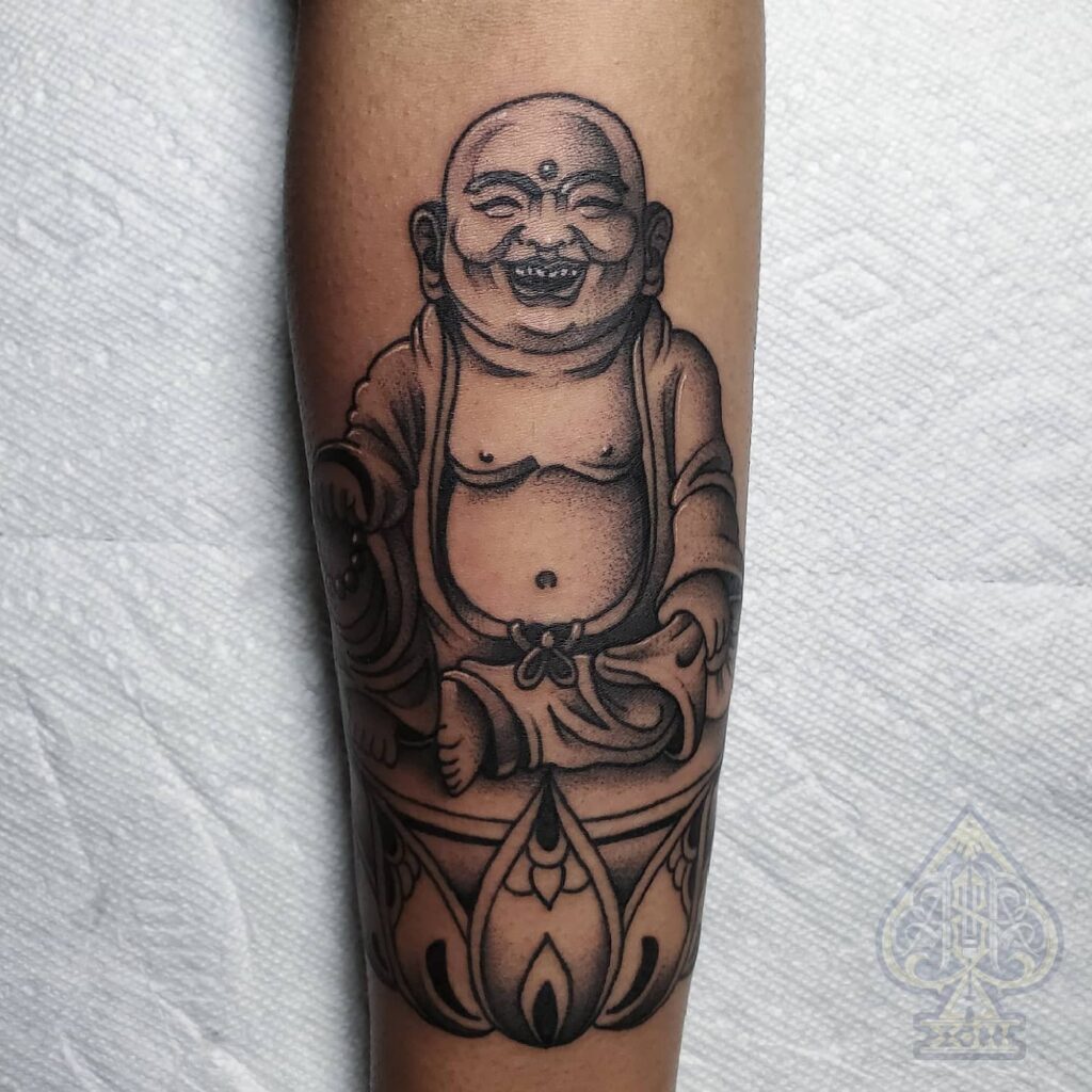 black and grey male meaningful laughing buddha forearm tattoo 