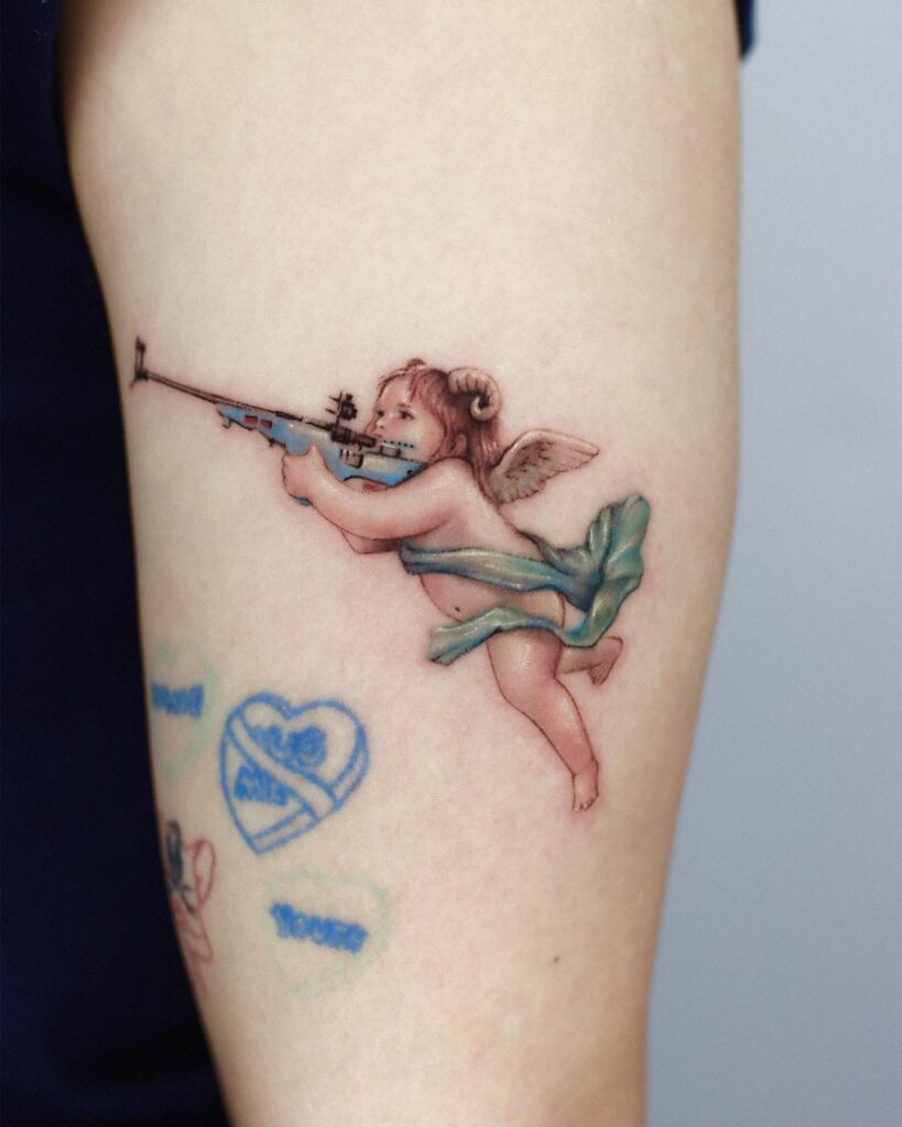 Colorful Baby Angel With Gun Tattoo Design