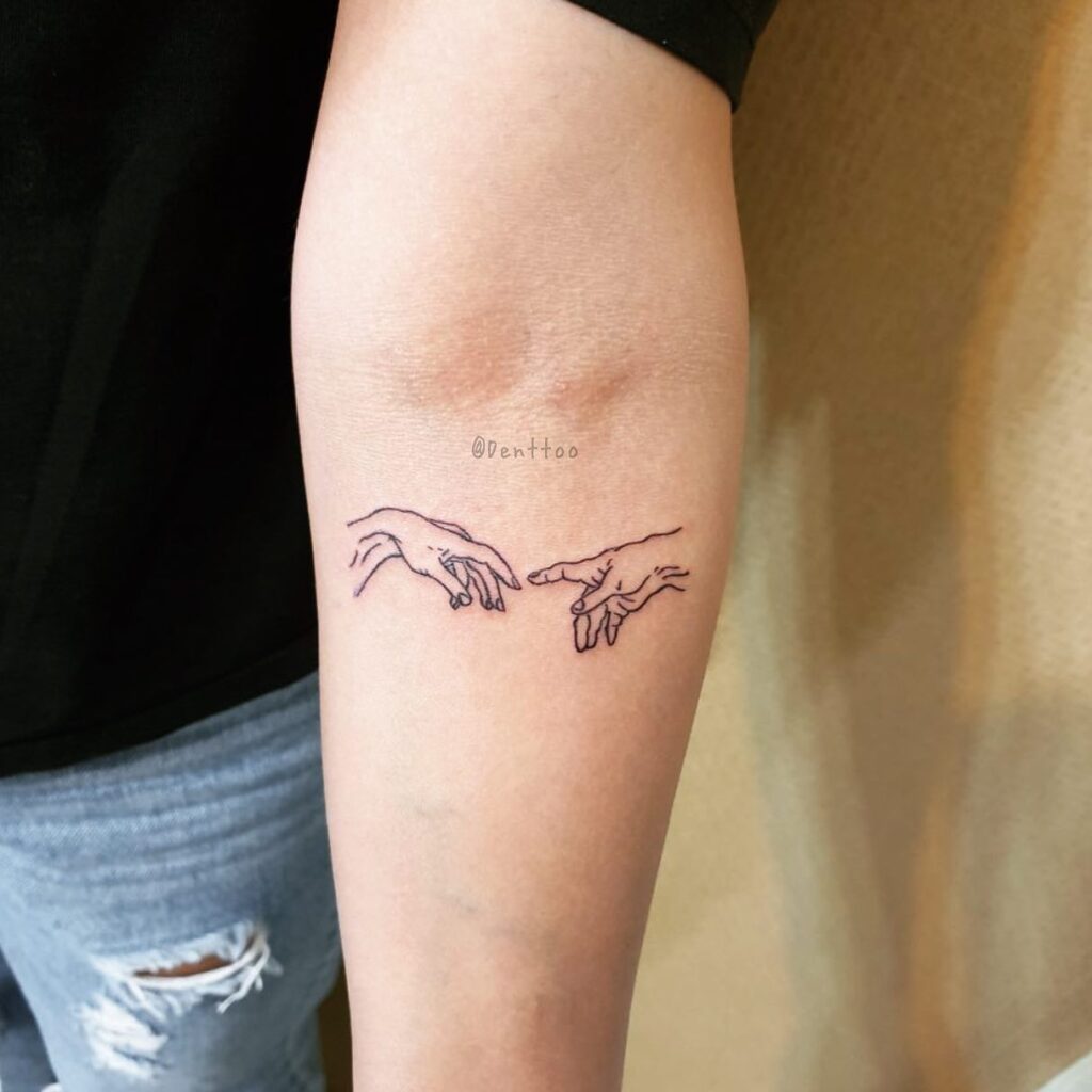 'Creation of Adam' Tattoo Art Gracing the Forearm: Divine Connection