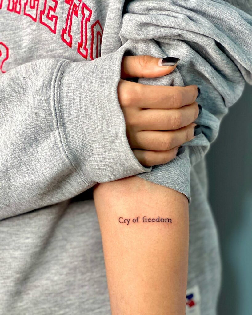 'Cry of Freedom' Clear Font Text Lettering Tattoo on the Forearm: Freedom's Echo