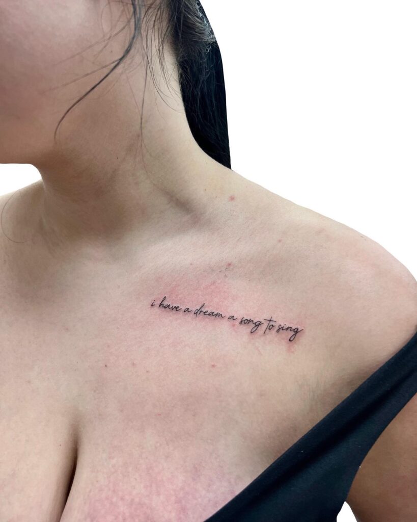 'i have a dream, a song to sing' script tattoo on collarbone, capturing lyrics in ink melodic dreams