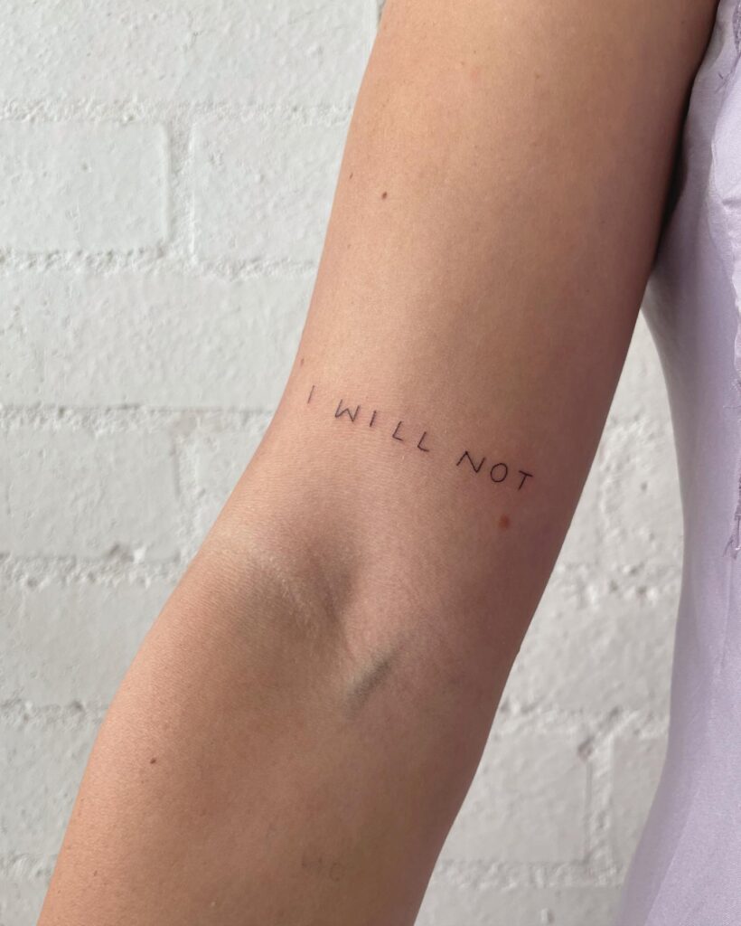 'I Will Not' Fineline Text Lettering Tattoo on the Above the Elbow: Resolute Spirit