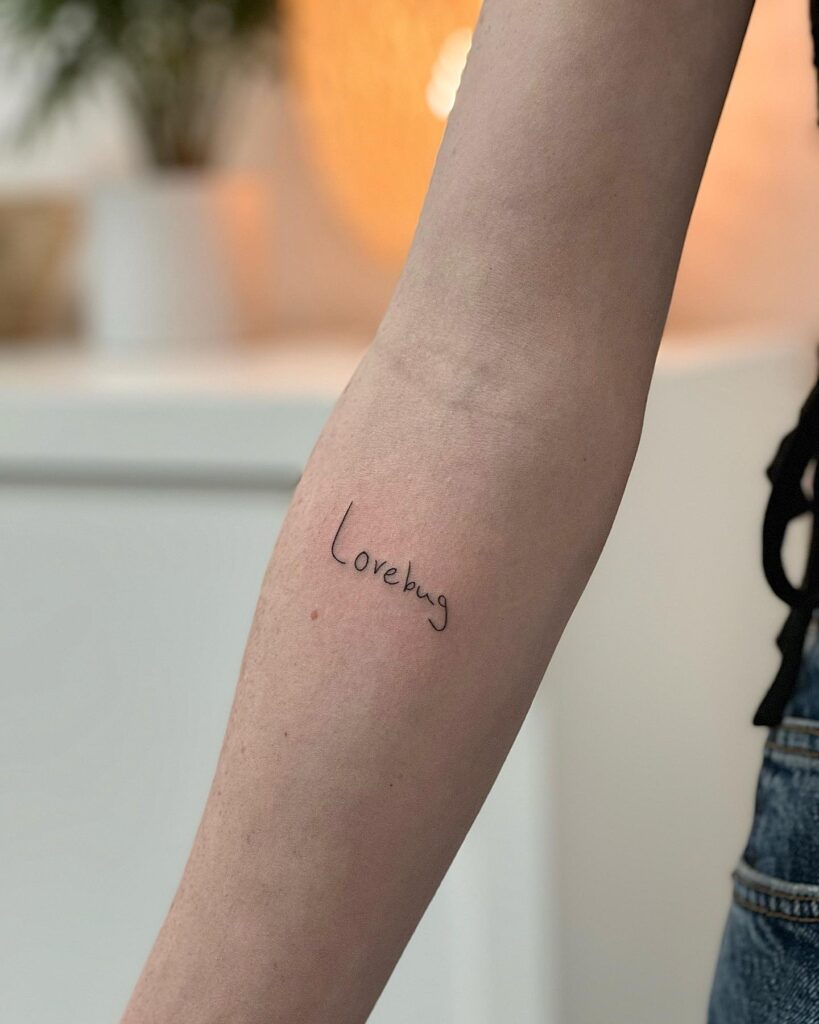 'Lovebug' Text Lettering Handwriting Tattoo on the Forearm: Love in Script