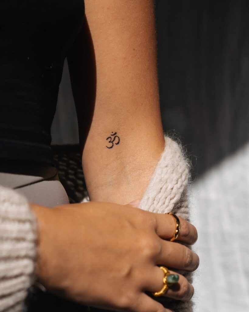'Om' Symbol Tattoo on the Inner Elbow: Spiritual Resonance