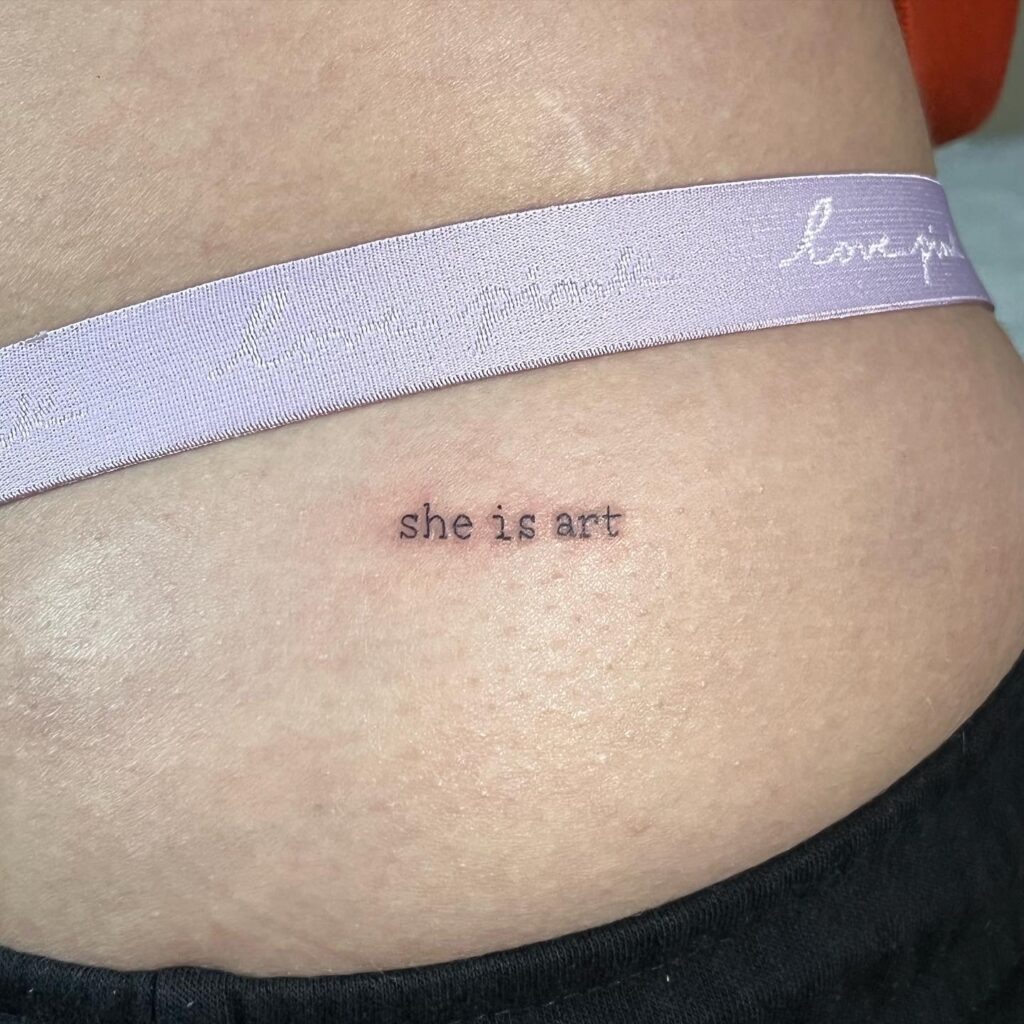 'She is Art' Text Lettering Tattoo on the Hip for Females: Artistry Unveiled