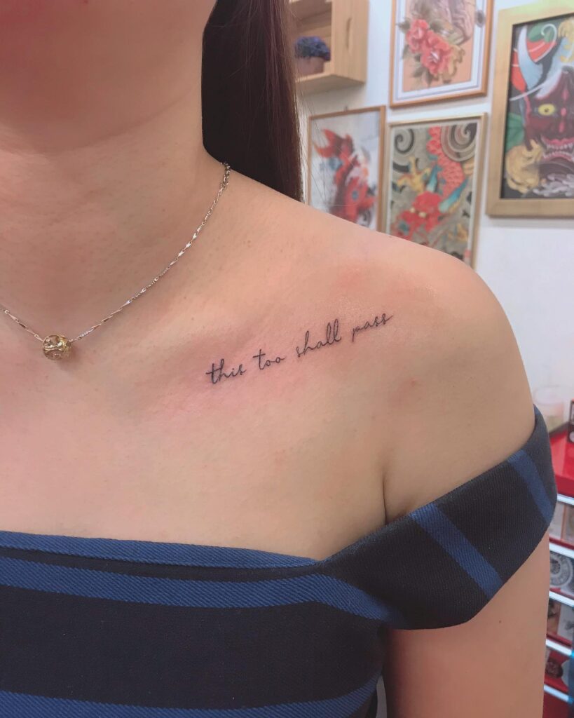 'this too shall pass' text lettering tattoo on the collarbone, a reminder of resilience transient wisdom